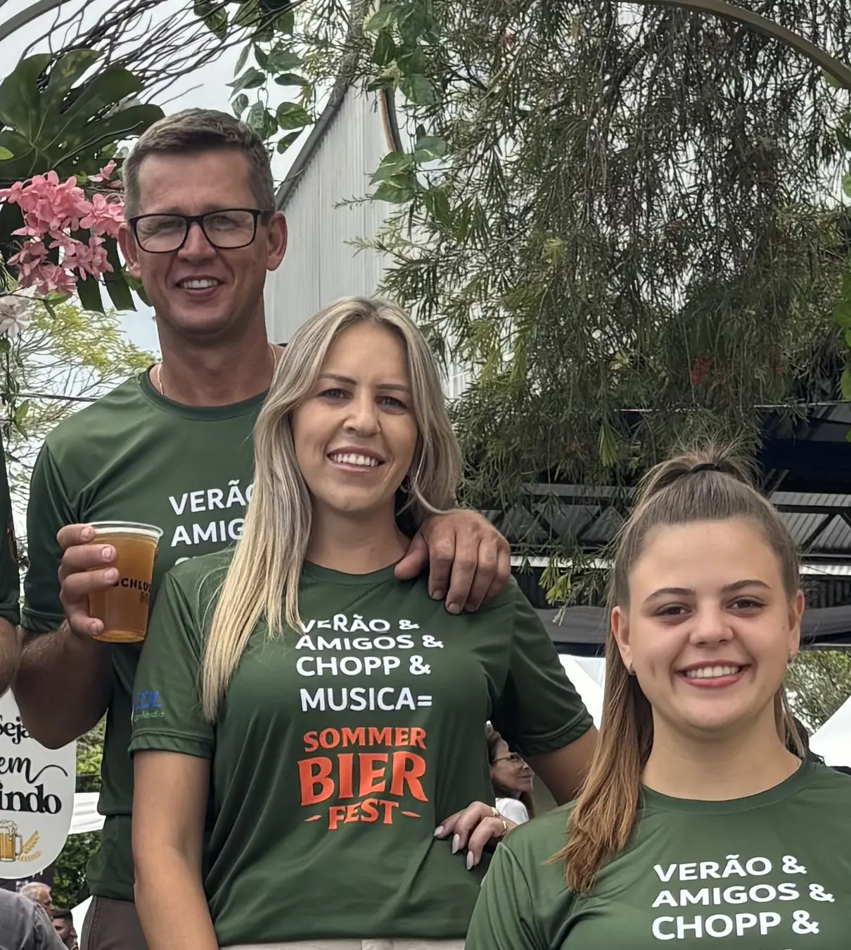 Três integrantes da equipe sorriem com a camiseta verde do Sommer Bier Fest
