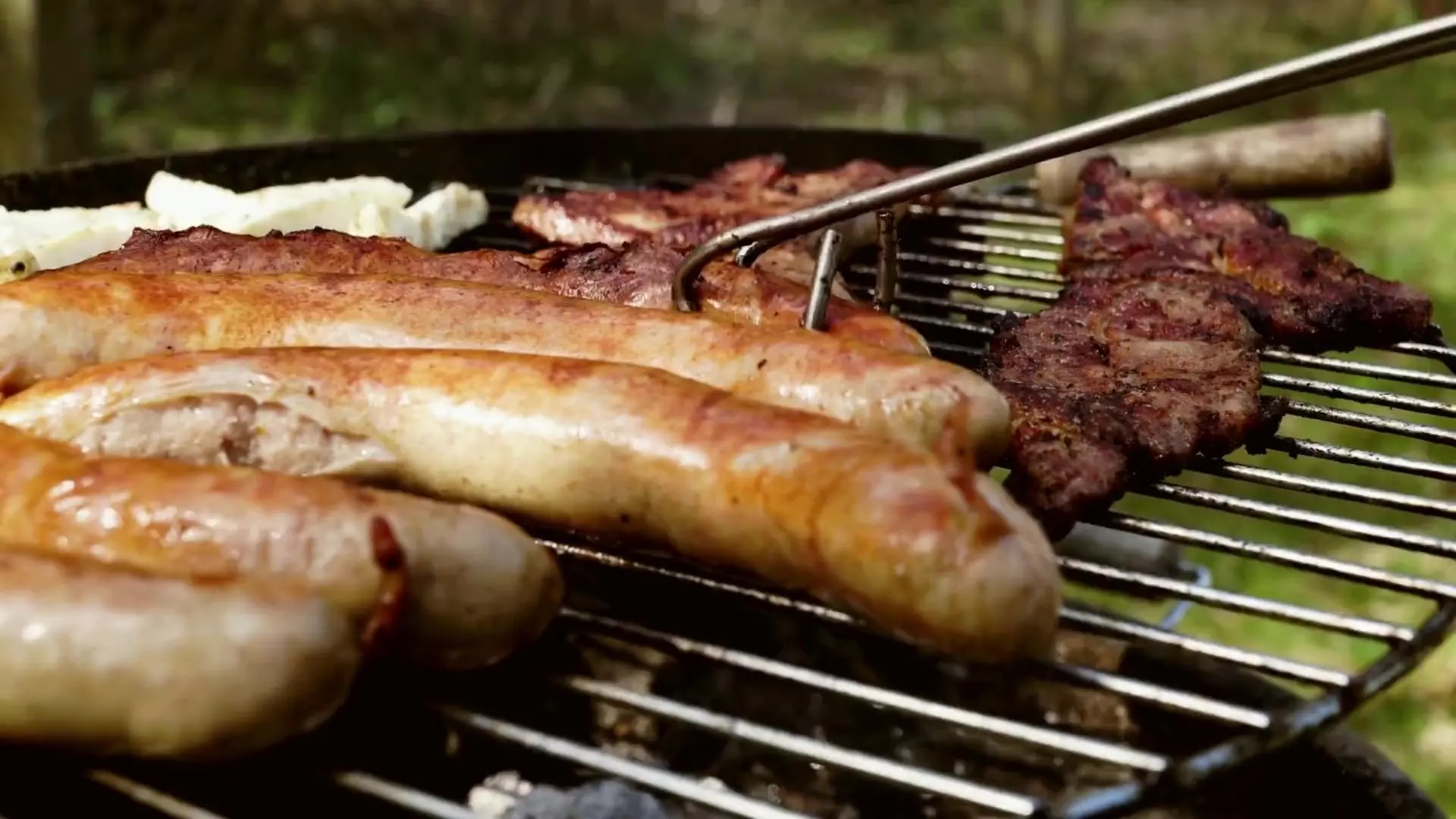 Linguiças e carnes assando na grelha ao ar livre