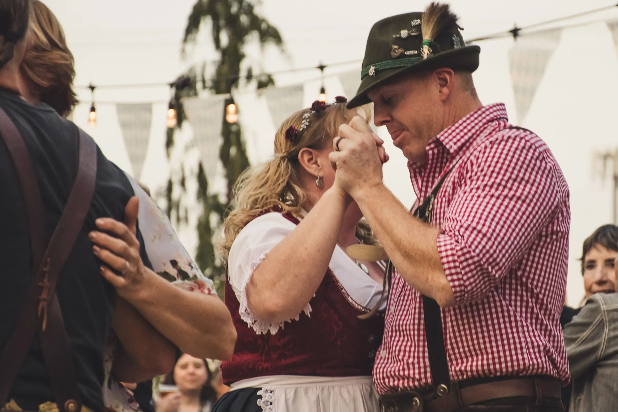 Casal com trajes típicos alemães dançando durante uma festa